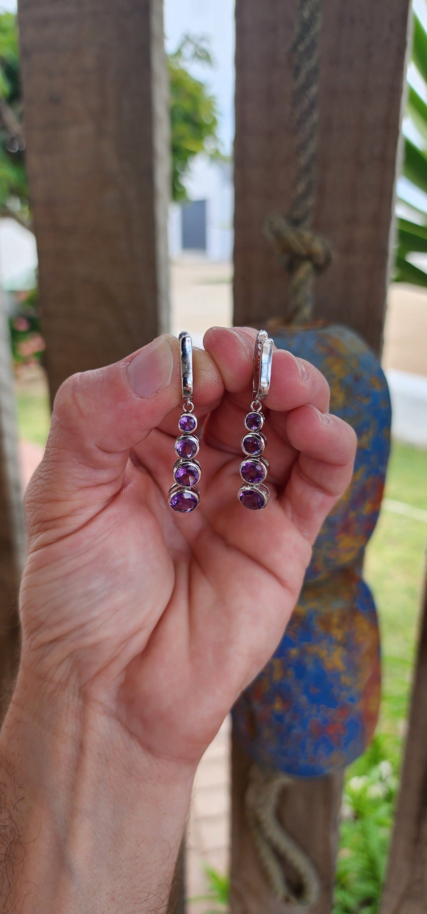 These sterling silver drop earrings are absolutely beautiful. Each earring features four bezel-set, round-cut amethysts arranged in a graduated design that seamlessly transitions from smaller stones at the top to larger ones at the base.