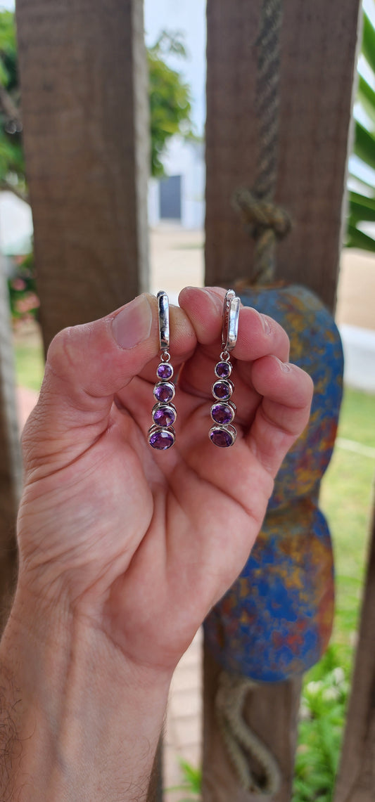 These sterling silver drop earrings are absolutely beautiful. Each earring features four bezel-set, round-cut amethysts arranged in a graduated design that seamlessly transitions from smaller stones at the top to larger ones at the base.