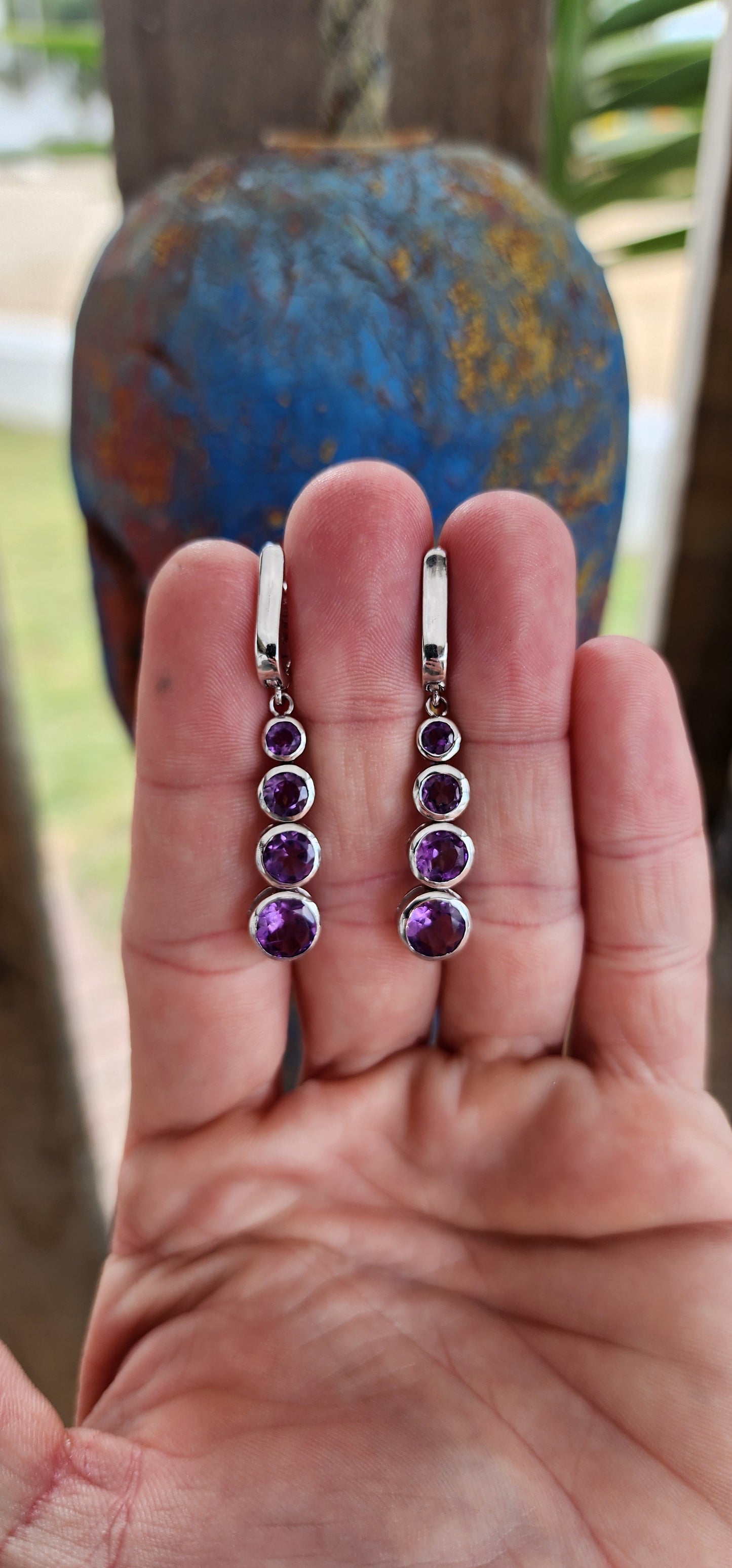 These sterling silver drop earrings are absolutely beautiful. Each earring features four bezel-set, round-cut amethysts arranged in a graduated design that seamlessly transitions from smaller stones at the top to larger ones at the base.