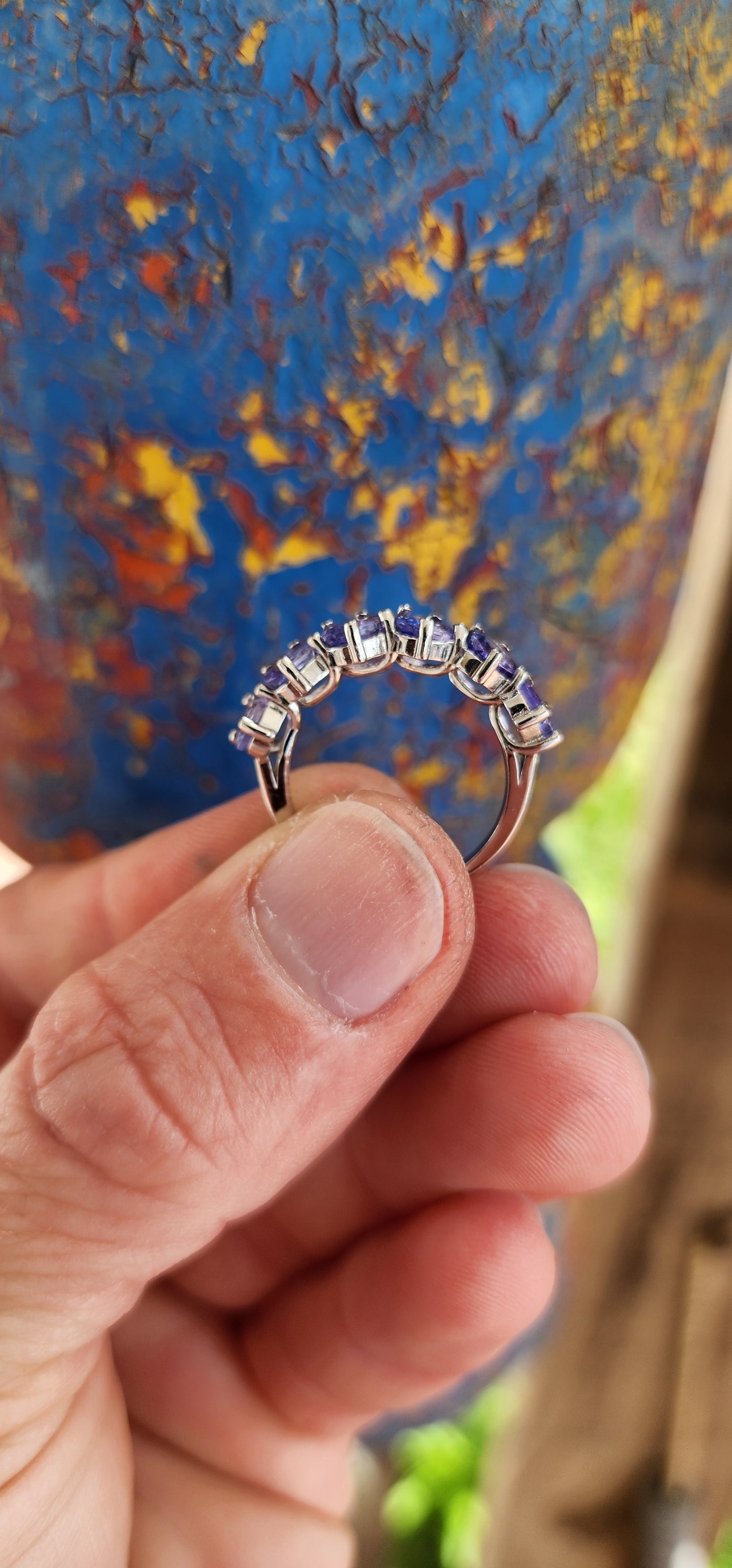 This exquisite sterling silver half-eternity ring showcases six oval faceted-cut Tanzanite gemstones, each carefully set in a four-claw setting for maximum visibility and brilliance.