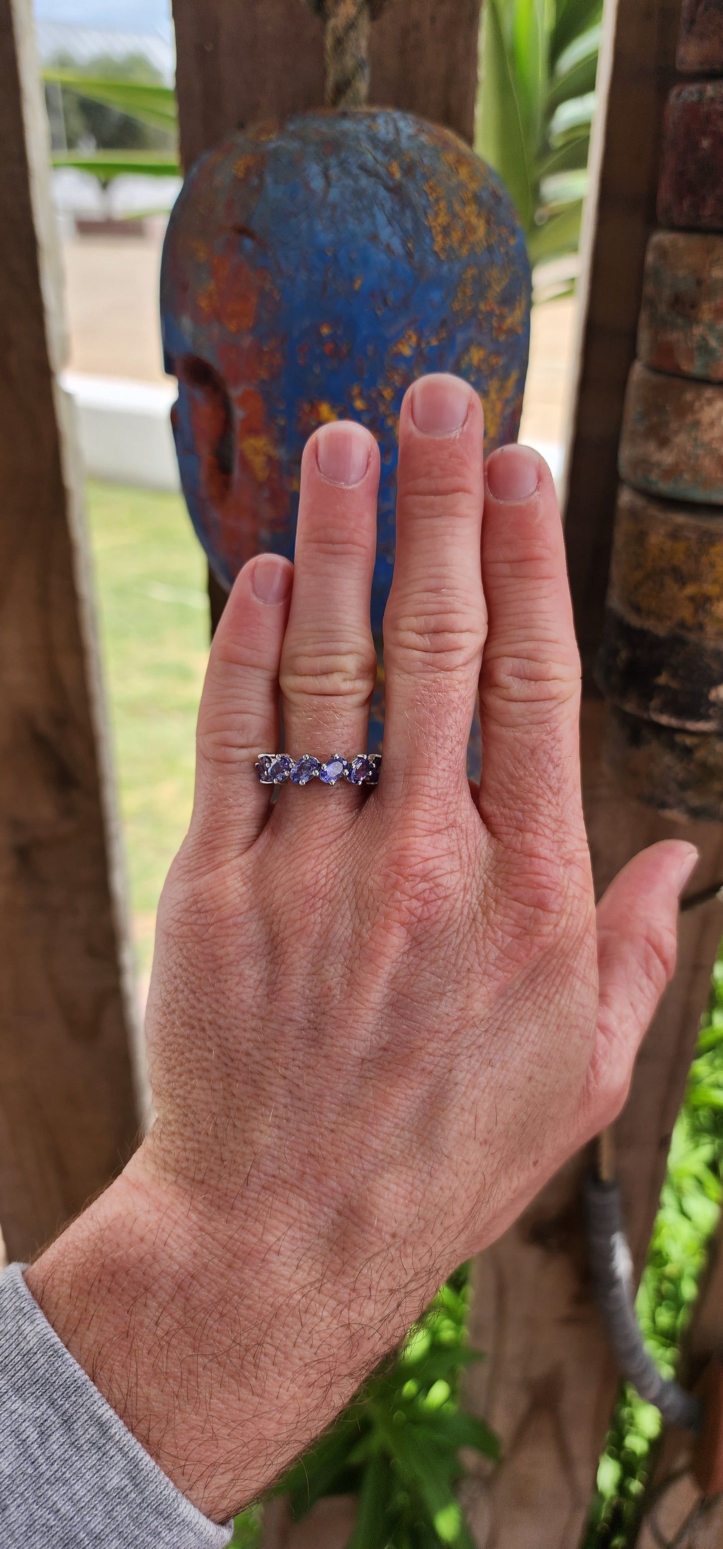 This exquisite sterling silver half-eternity ring showcases six oval faceted-cut Tanzanite gemstones, each carefully set in a four-claw setting for maximum visibility and brilliance.