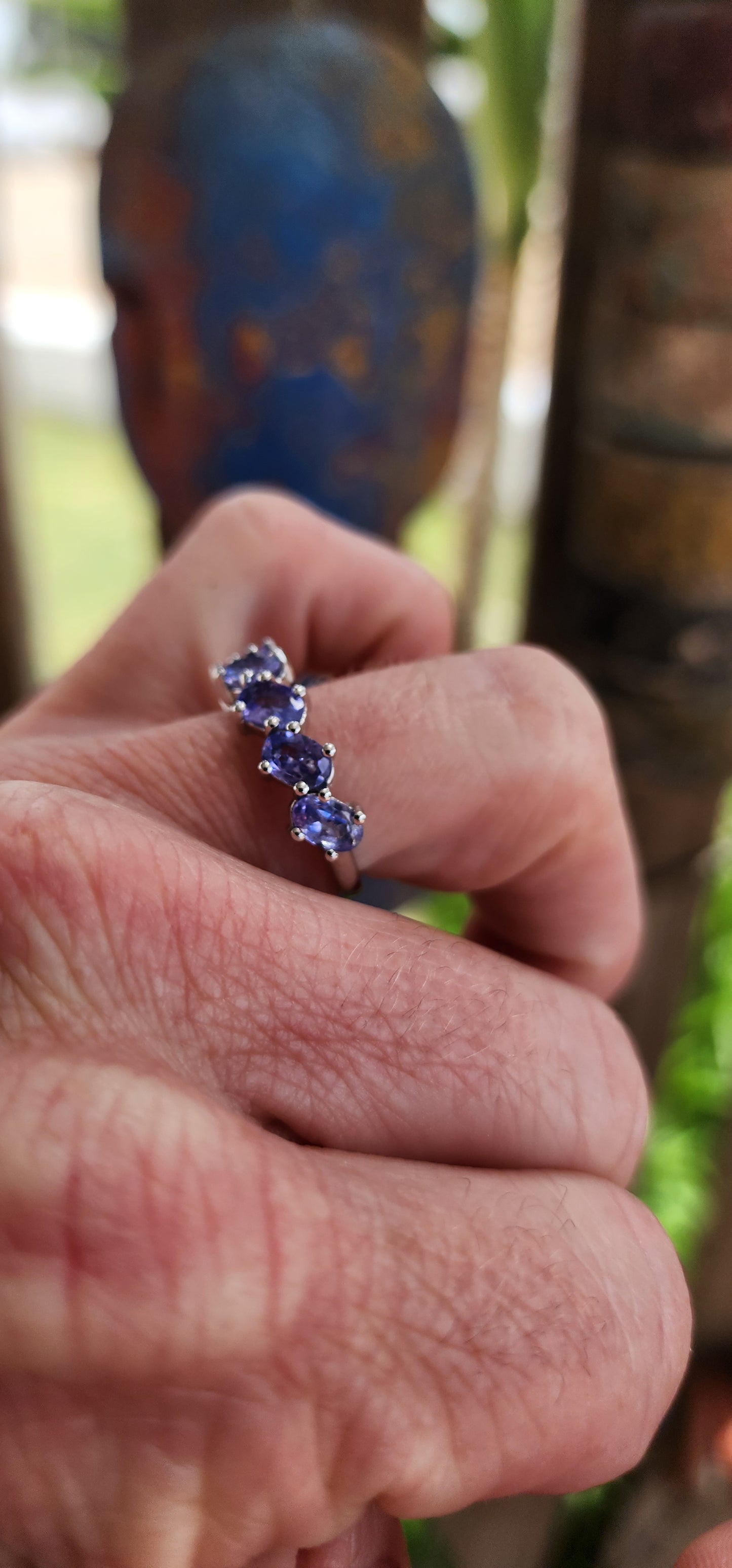 This exquisite sterling silver half-eternity ring showcases six oval faceted-cut Tanzanite gemstones, each carefully set in a four-claw setting for maximum visibility and brilliance.