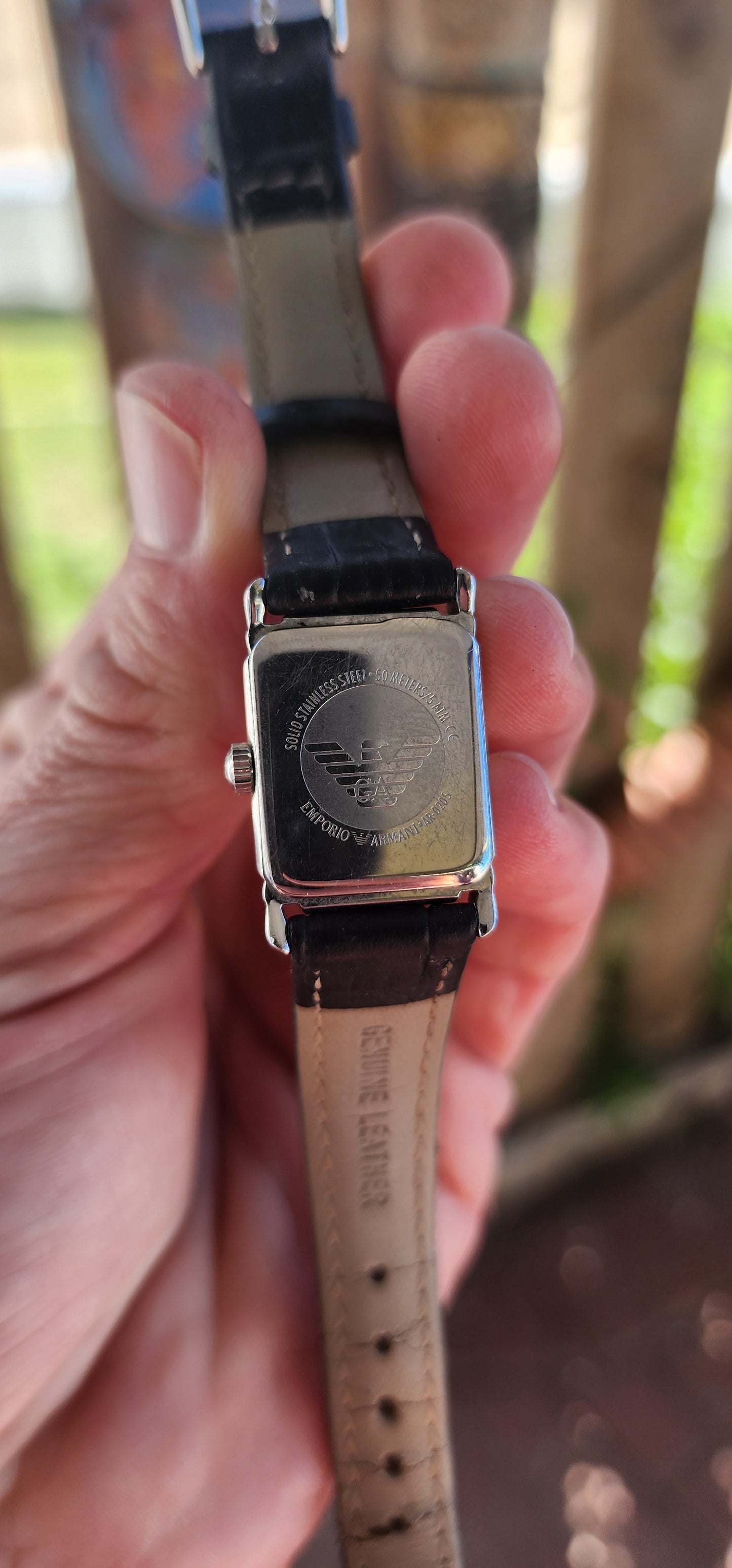 This elegant vintage Emporio Armani "AR0205" watch features a sophisticated vintage design with a rectangular stainless steel case and a beige analog dial.