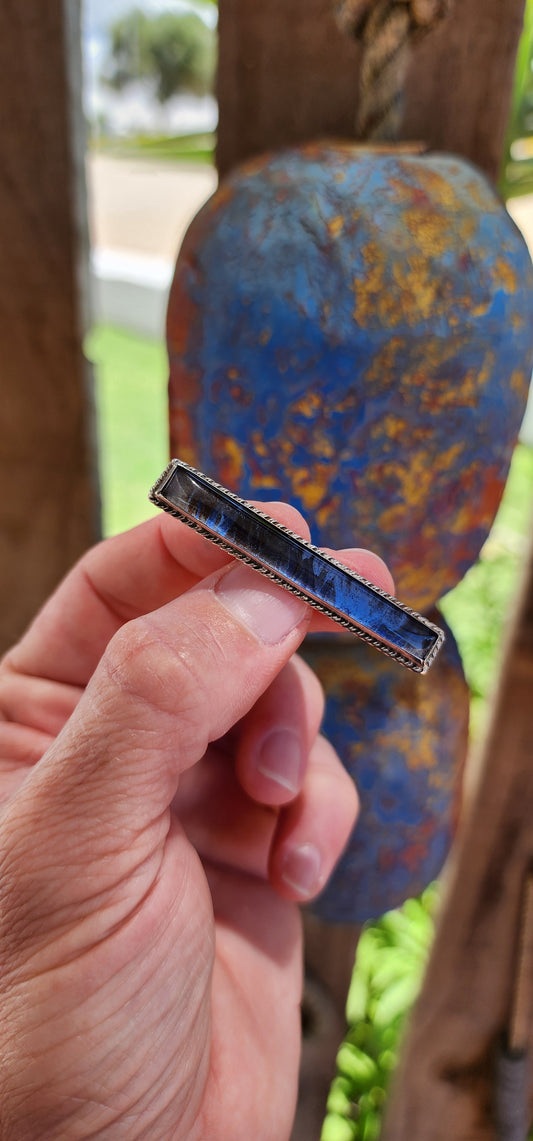 This brooch is a beautiful Art Deco-era piece, dating back to the 1930s. Its slender, rectangular bar design features a convex glass top that protects and magnifies the iridescent natural morpho butterfly wing beneath.