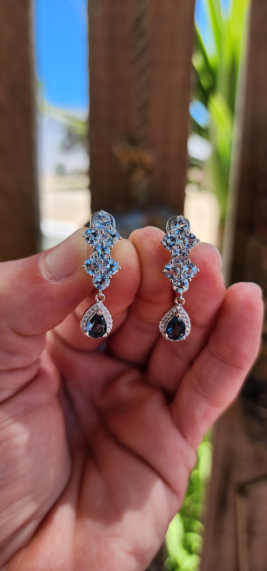 These elegant sterling silver drop earrings are a dazzling celebration of topaz gemstones and expert craftsmanship.