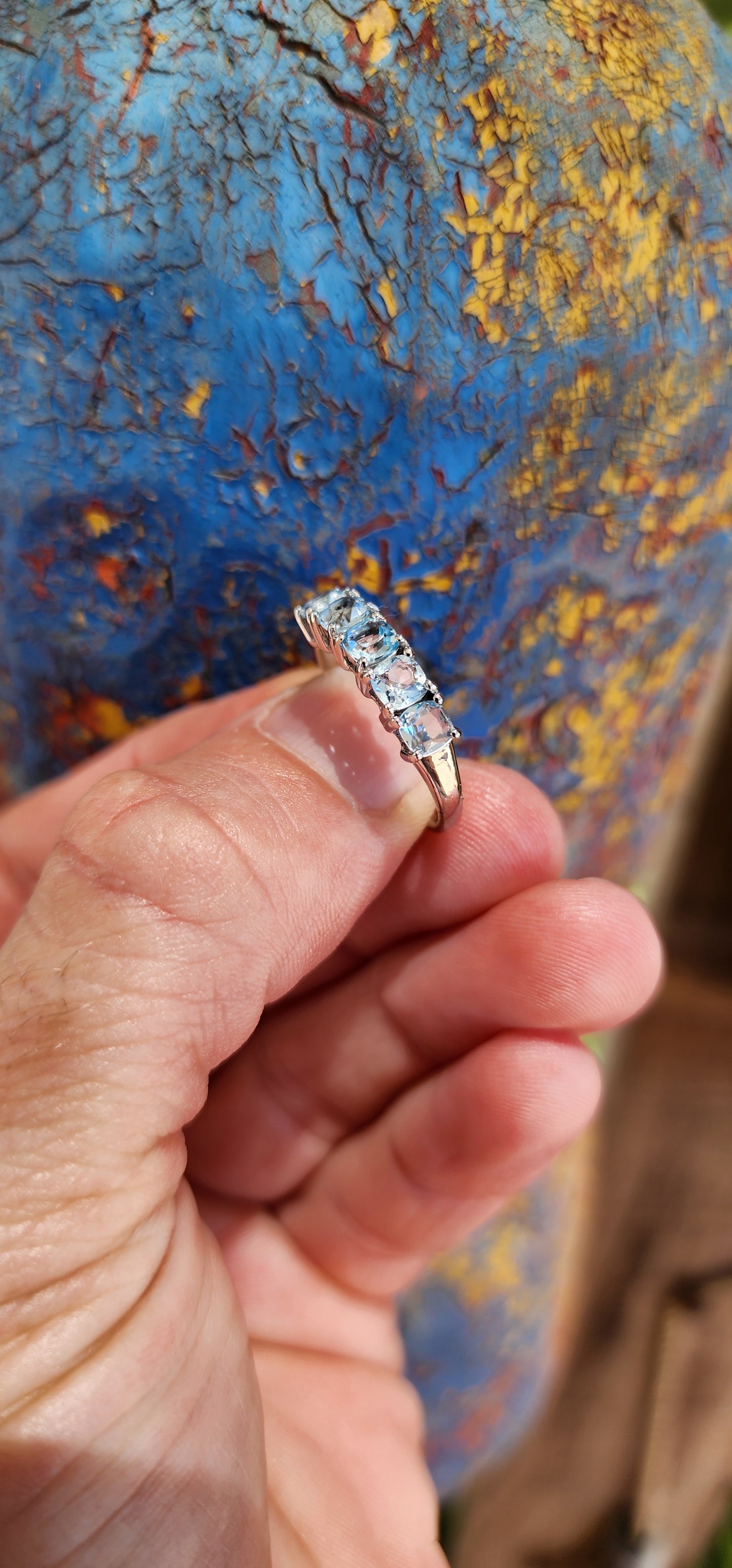 This beautiful sterling silver half-eternity ring features five cushion-cut sky-blue topaz gemstones that are securely set in prong settings.