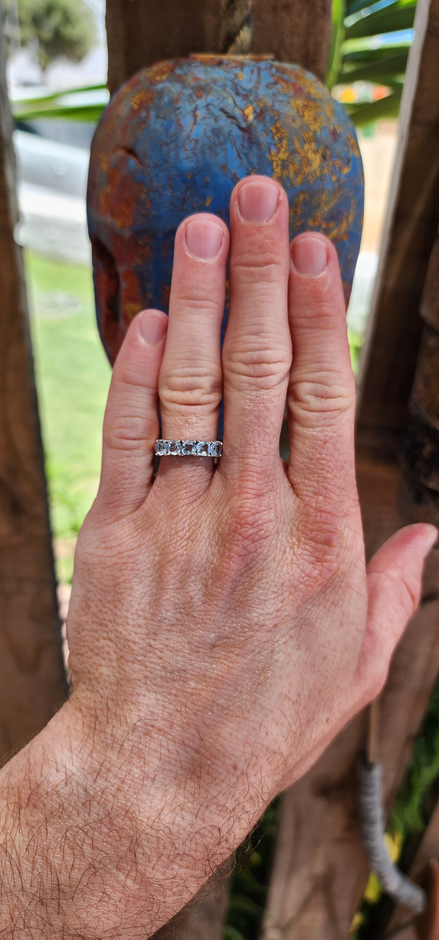 This beautiful sterling silver half-eternity ring features five cushion-cut sky-blue topaz gemstones that are securely set in prong settings.