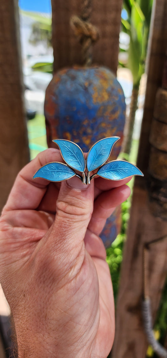 This 1950s Modernist David Andersen/Willy Winnaess sterling silver and blue enamel guilloché leaves brooch is a true masterpiece of Scandinavian design and craftsmanship, embodying the essence of mid-century modernism.