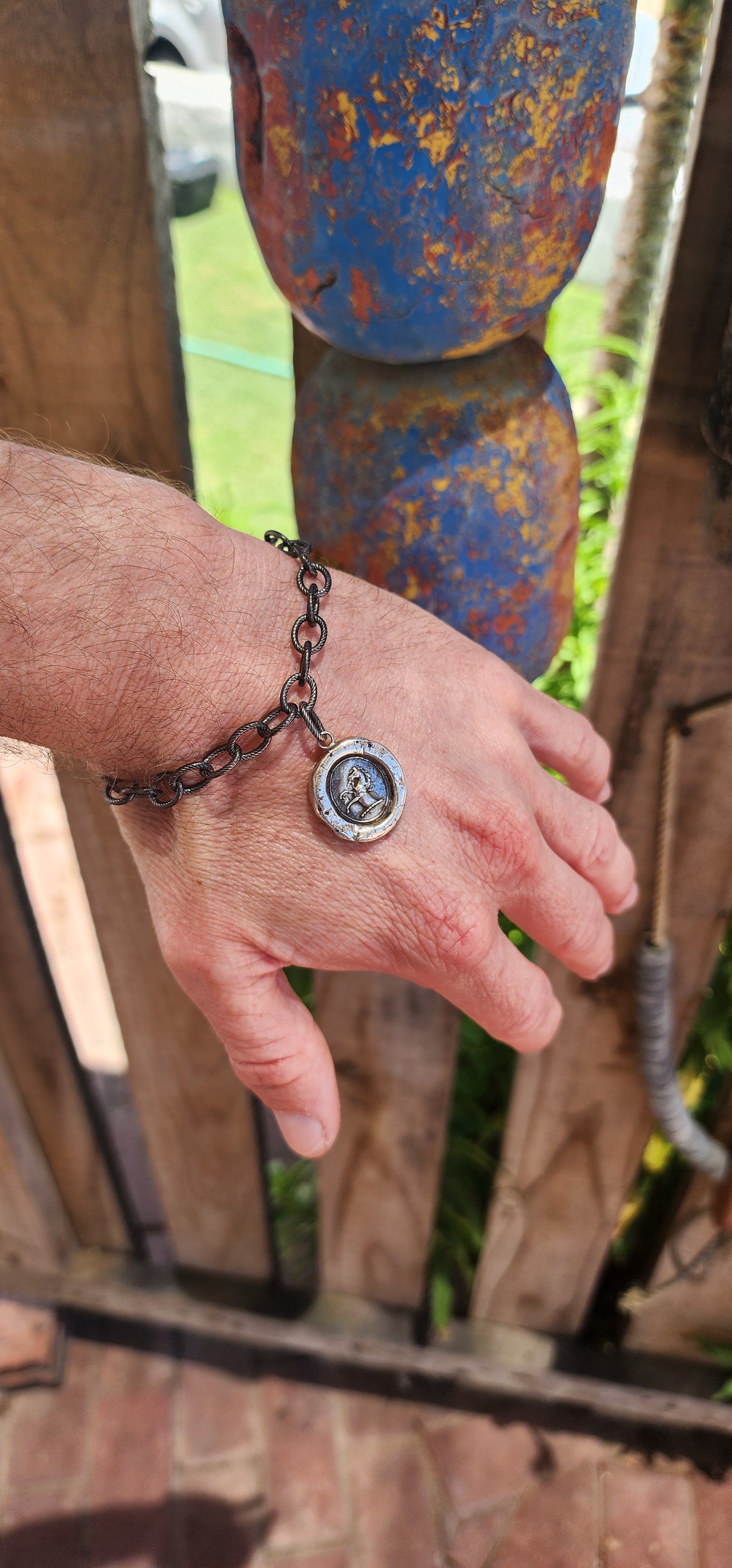 This artisan-crafted sterling silver bracelet with heraldic wax seal pendant is a wearable work of art, steeped in historical charm and symbolic meaning.