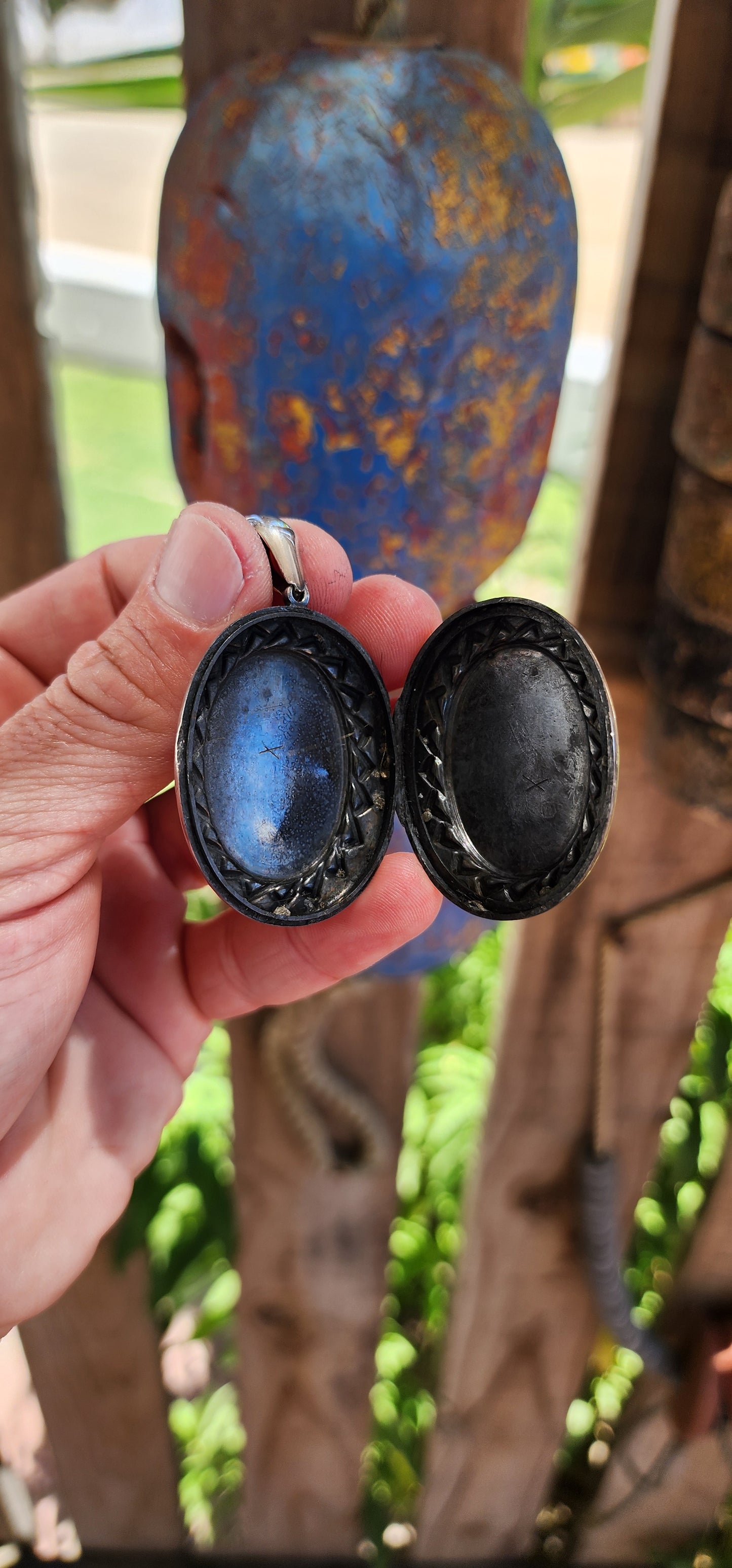 This large sized locket is a beautiful example of Victorian-era craftsmanship, designed in a sterling silver oval shape with a striking sunburst pattern encircling the center on both sides.