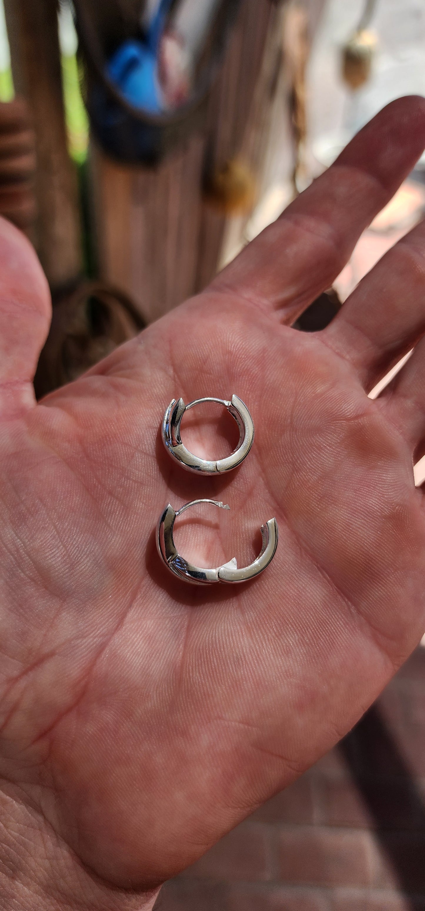 These stunning sterling silver huggie earrings are a masterpiece contemporary design. Their form exudes sophistication, featuring an X-shaped cross-over pattern that seamlessly combines polished silver with a soft, brushed texture.