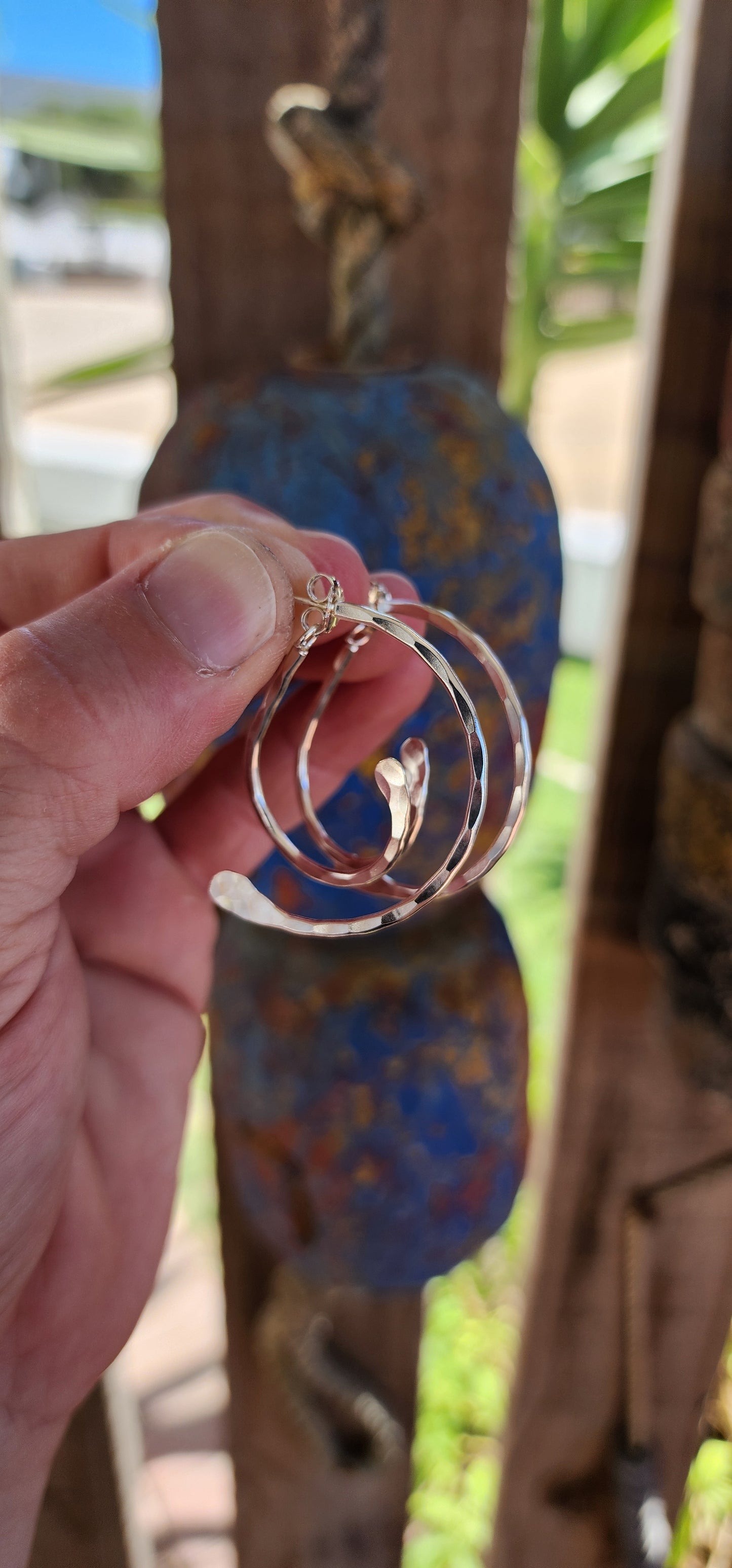 These earrings are a brilliant fusion of contemporary artistry and optical illusion! Crafted from hammered sterling silver, they feature an intriguing twisted double-half hoop design that plays with depth and dimension.