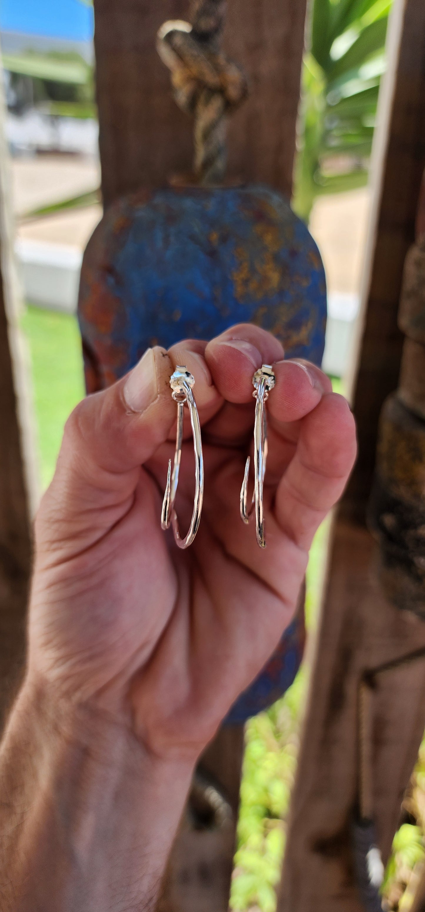 These earrings are a brilliant fusion of contemporary artistry and optical illusion! Crafted from hammered sterling silver, they feature an intriguing twisted double-half hoop design that plays with depth and dimension.