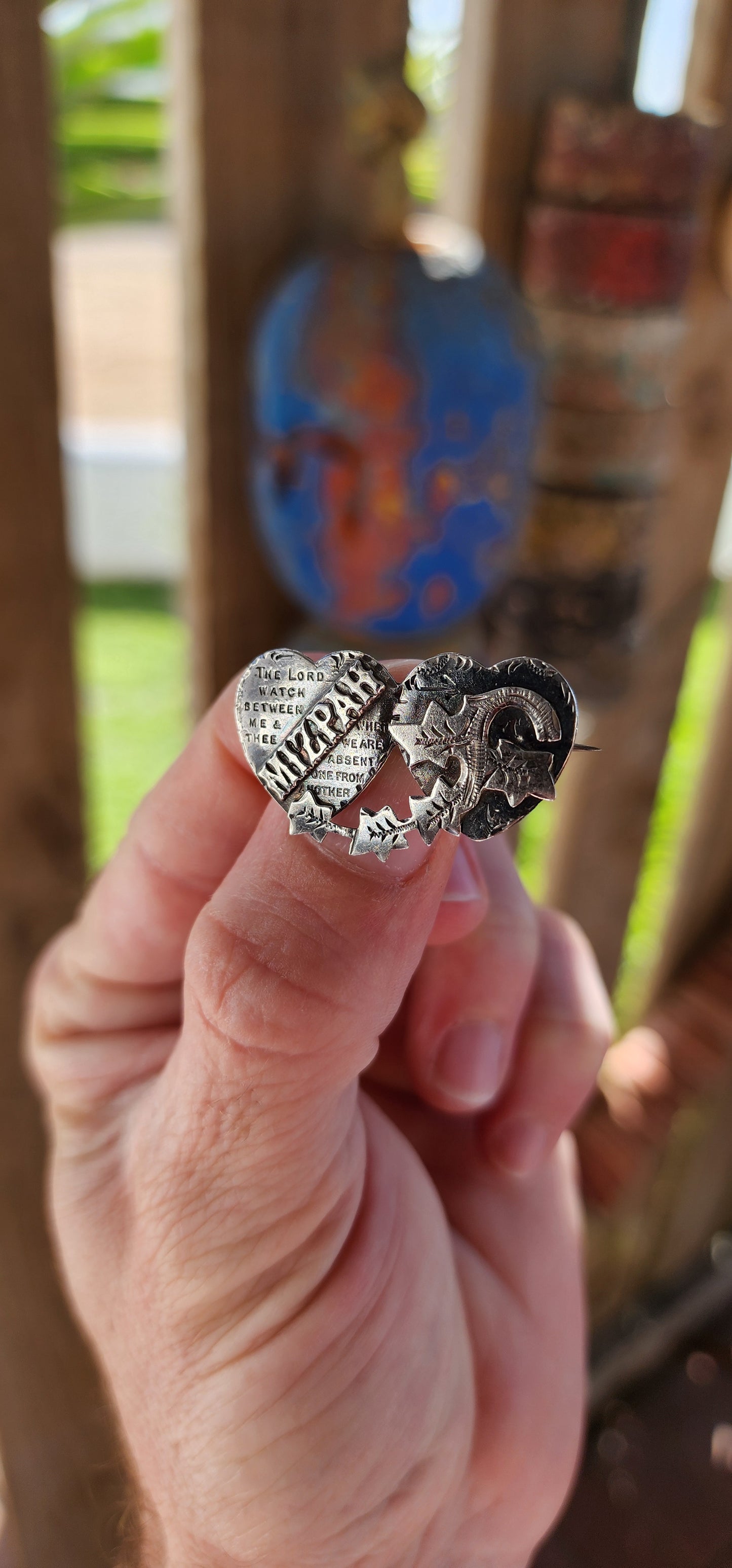 This antique Victorian Mizpah brooch is a finely crafted sentimental jewelry piece, made from solid sterling silver, and designed in the shape of two interlocking hearts.