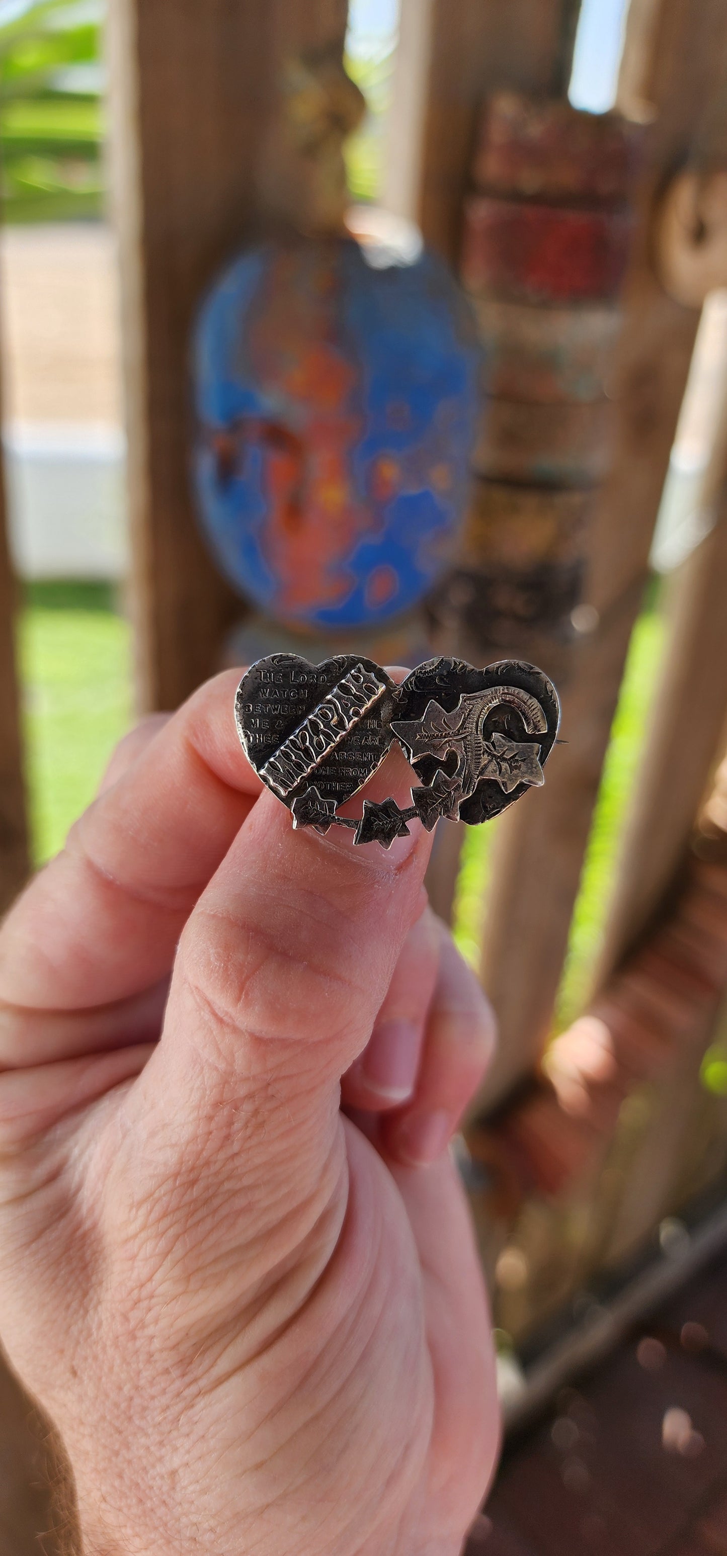 This antique Victorian Mizpah brooch is a finely crafted sentimental jewelry piece, made from solid sterling silver, and designed in the shape of two interlocking hearts.