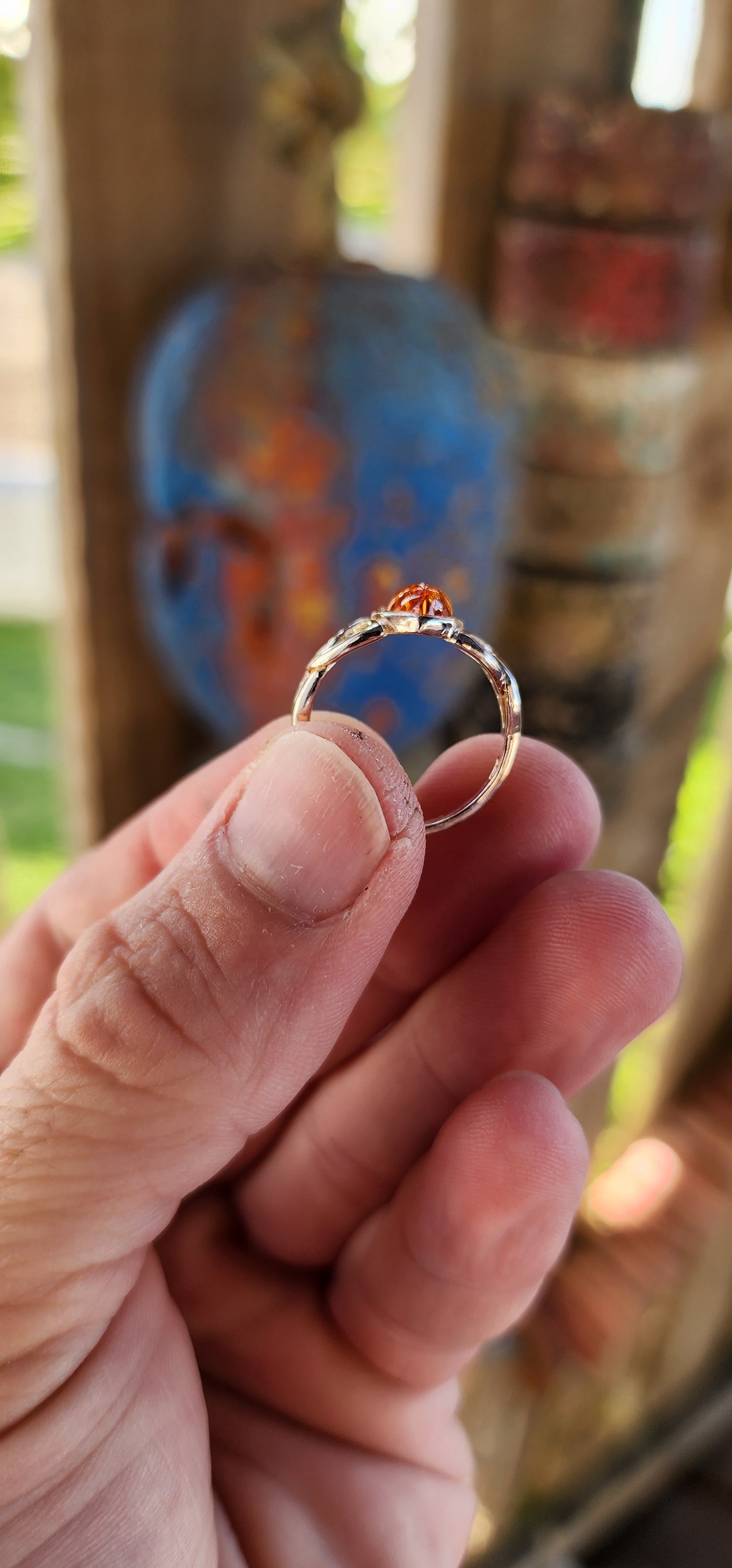 This sterling silver ring is a masterpiece of both elegance and symbolism, its design rooted in ancient Celtic tradition. At the heart of the piece rests a marquise-cut Baltic amber cabochon, its golden depths shimmering like liquid sunlight.