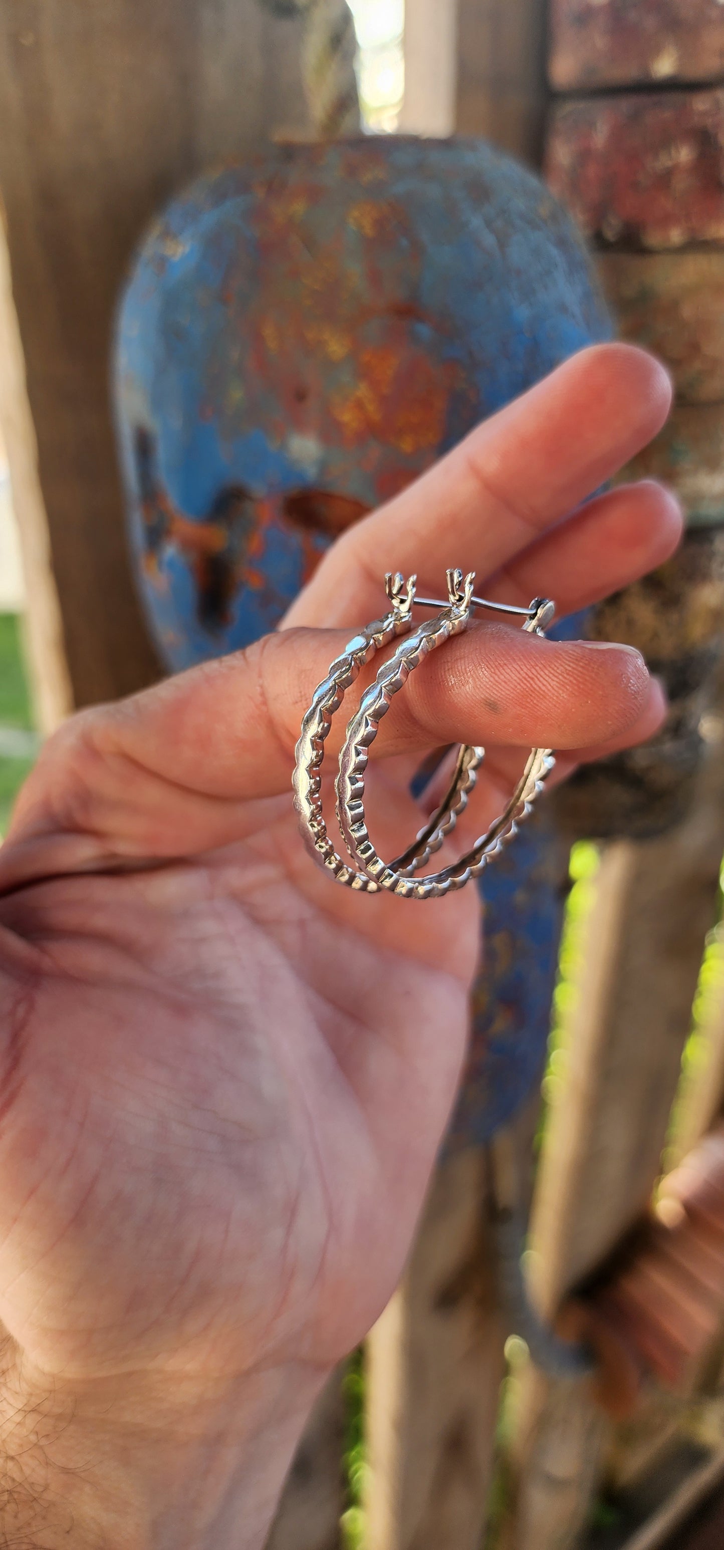 These trusty pair of generous-sized sterling silver hoop earrings are the epitome of vintage-inspired glamour and versatility. These statement hoops are crafted in lustrous sterling silver, exuding a timeless elegance.