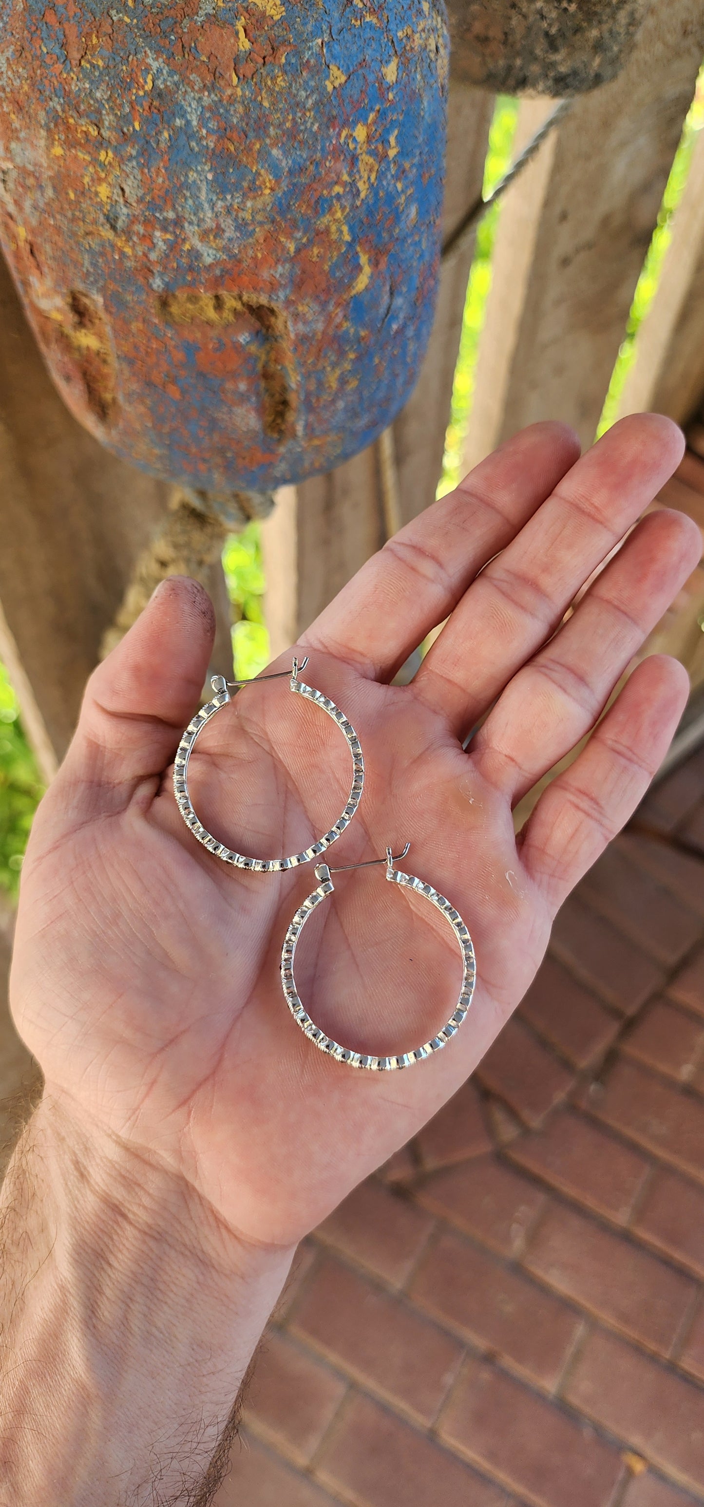 These trusty pair of generous-sized sterling silver hoop earrings are the epitome of vintage-inspired glamour and versatility. These statement hoops are crafted in lustrous sterling silver, exuding a timeless elegance.