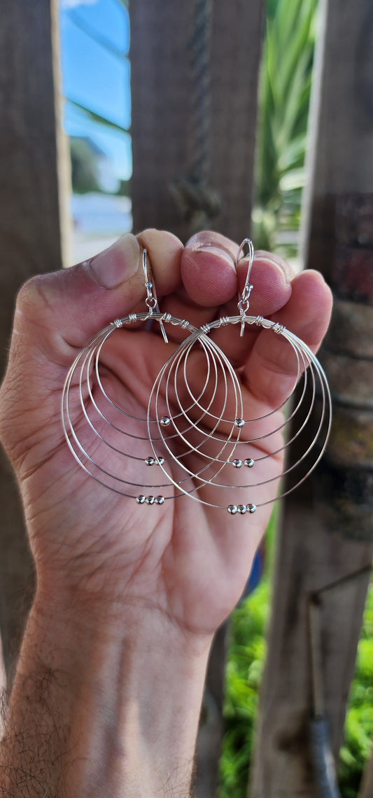 These sculptural stunners are a kinetic dream in sterling silver. Like minimalist mobiles plucked straight from a Calder sketch, each earring features five progressively sized, ultra-fine wire hoops nested within one another, curving in perfect harmony.