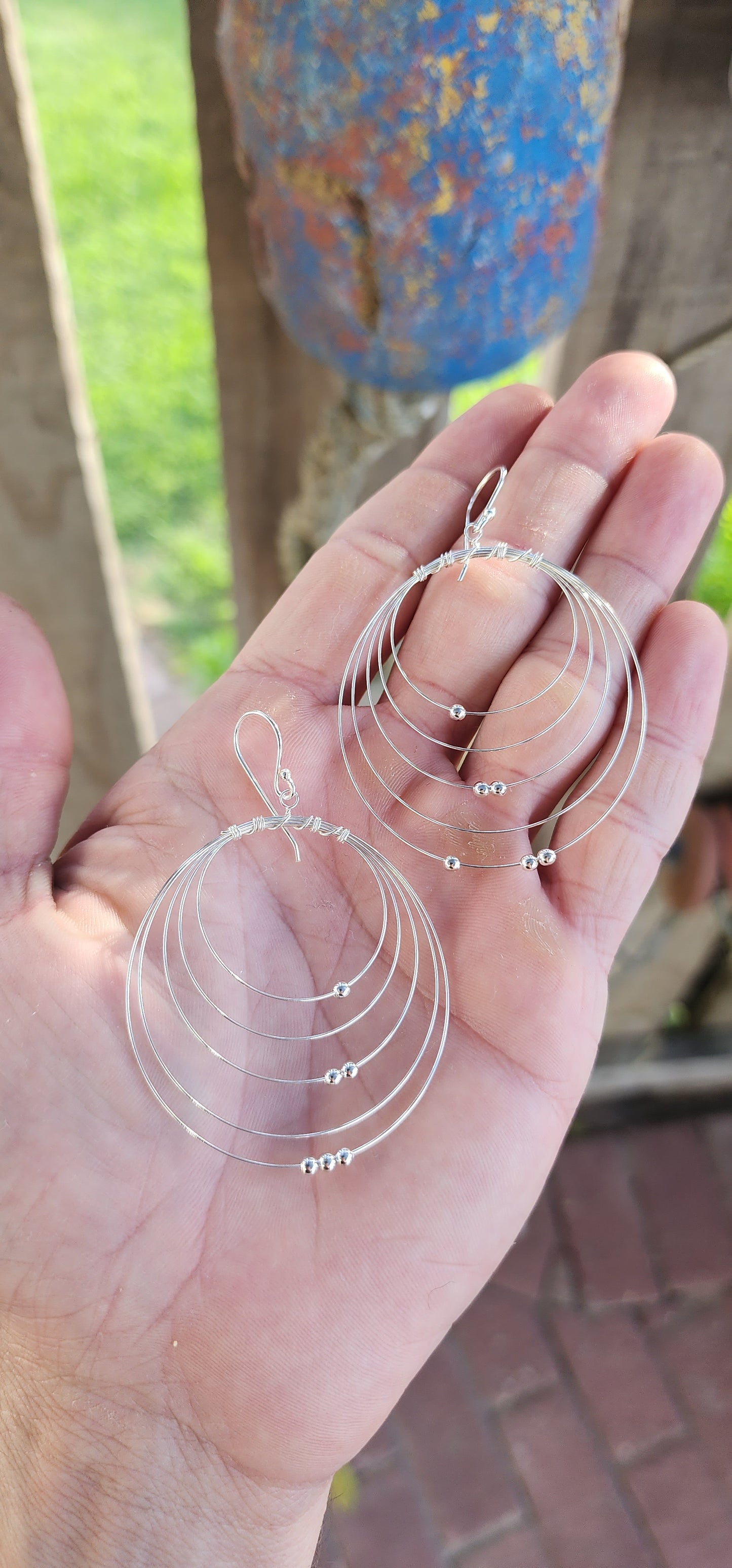 These sculptural stunners are a kinetic dream in sterling silver. Like minimalist mobiles plucked straight from a Calder sketch, each earring features five progressively sized, ultra-fine wire hoops nested within one another, curving in perfect harmony.