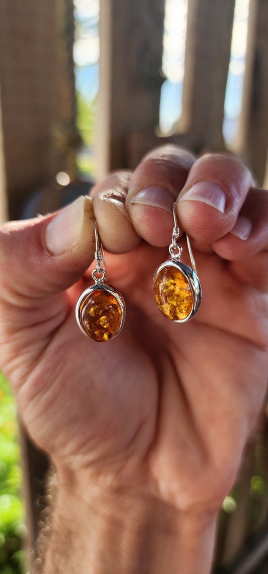 These beautiful earrings are bringing prehistoric glam to the party! Each drop features a glowing oval cabochon of genuine Baltic amber, bezel-set in polished sterling silver.