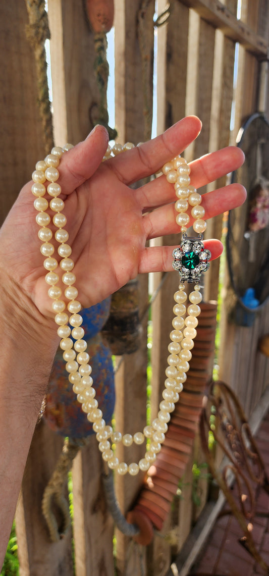 This fabulous Art Deco-era double strand costume necklace, dating to the glitzy 1940s, is pure vintage elegance with a side of silver screen sparkle. The strands are composed of rich, creamy glass faux pearls, each one lovingly hand-knotted.