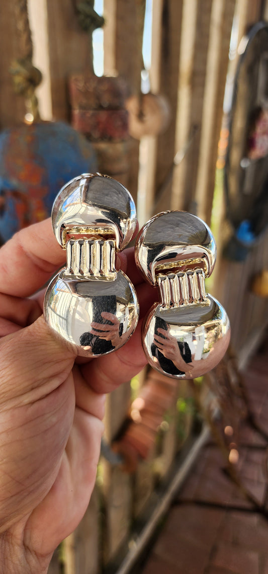 Architectural Chic from the Space Age!
Bold, sculptural, and irresistibly retro — this striking pair of vintage 1980s silver-plated costume clip-on earrings is like wearing a piece of modernist art straight from a design museum.
