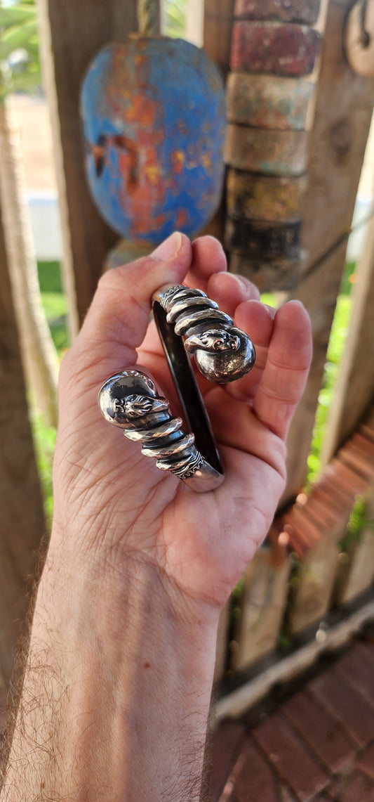 Antique Victorian-Era Etruscan Revival Double Coiled Serpent Cuff Bangle in 800 Silver.
A bold echo of ancient mystery and Victorian imagination, this antique double-headed serpent cuff bangle is a striking example of Etruscan Revival artistry in silver.