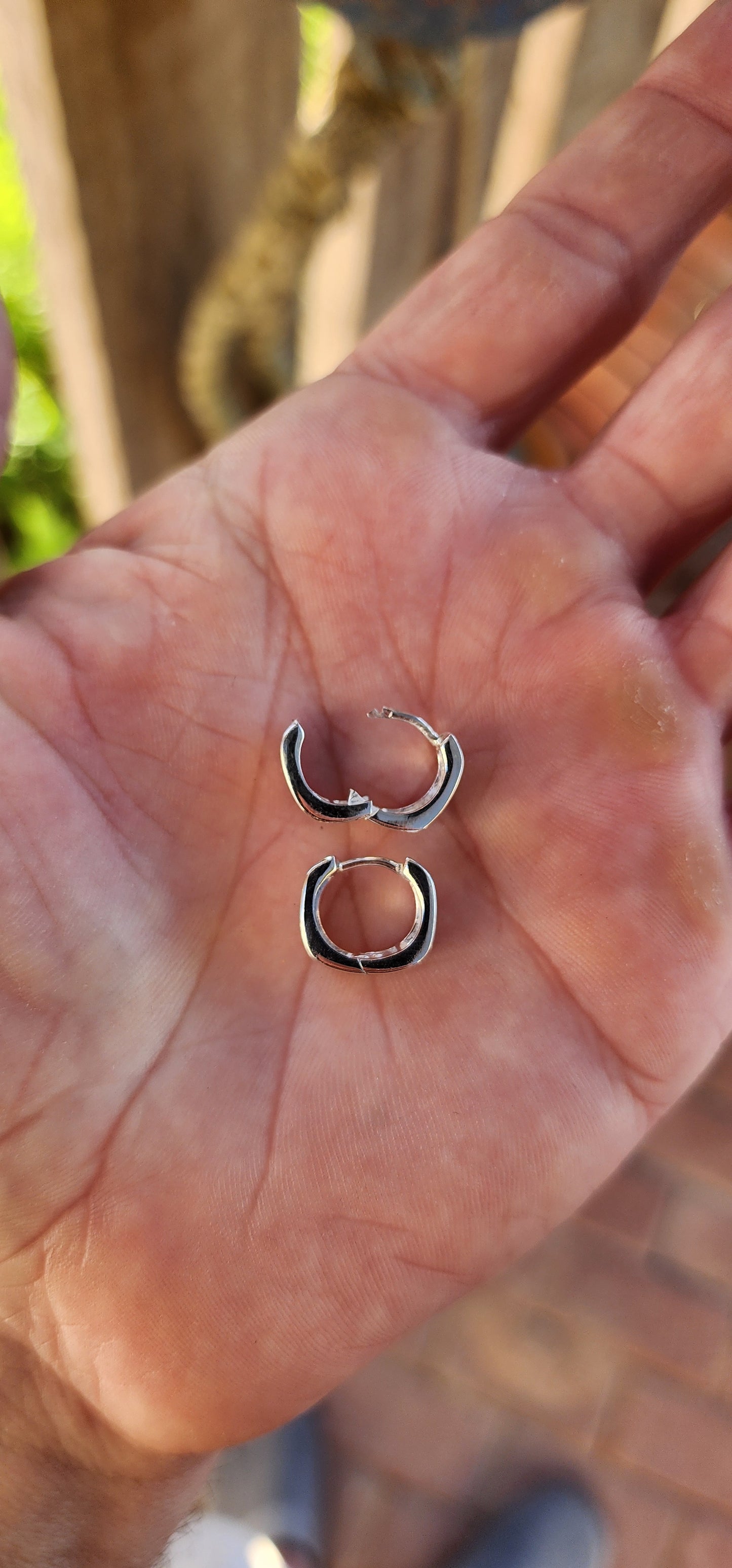 These sterling silver huggie earrings are a masterclass in modern minimalism, sculpted in a bold rounded-rectangular shape that hugs the ear with contemporary charm.