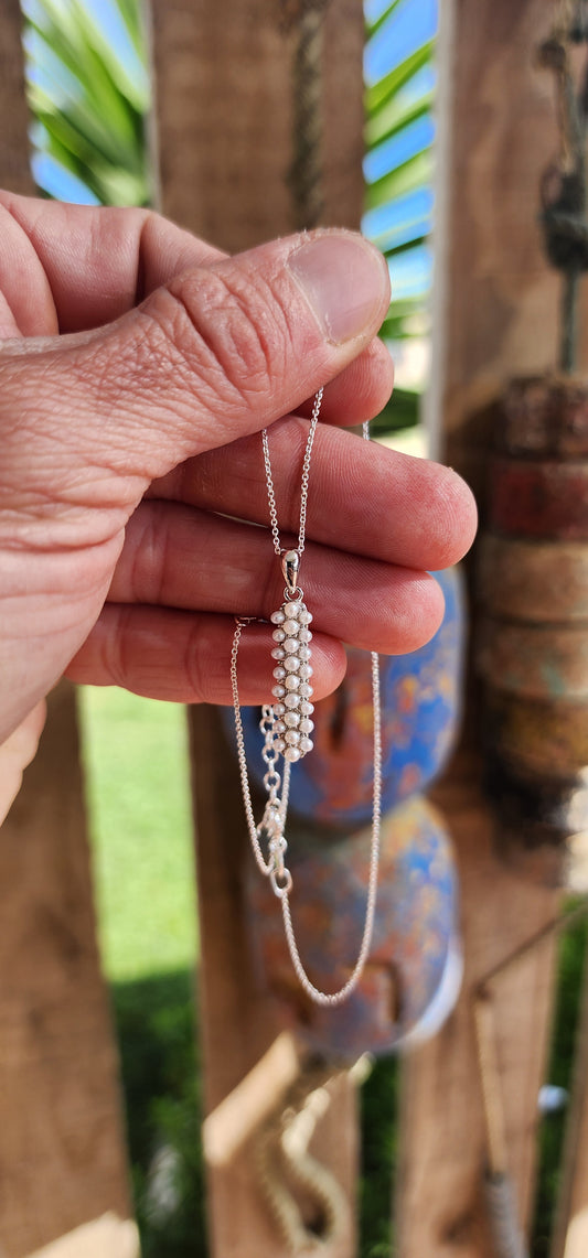 Drizzling elegance straight down your neckline, this sterling silver beauty is all about pearly perfection with a twist.