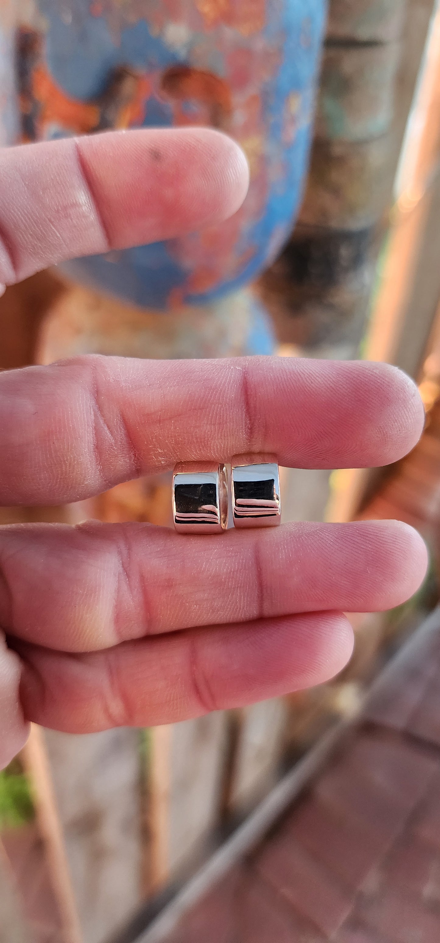 These sterling silver huggie earrings are a masterclass in modern minimalism, sculpted in a bold rounded-rectangular shape that hugs the ear with contemporary charm.