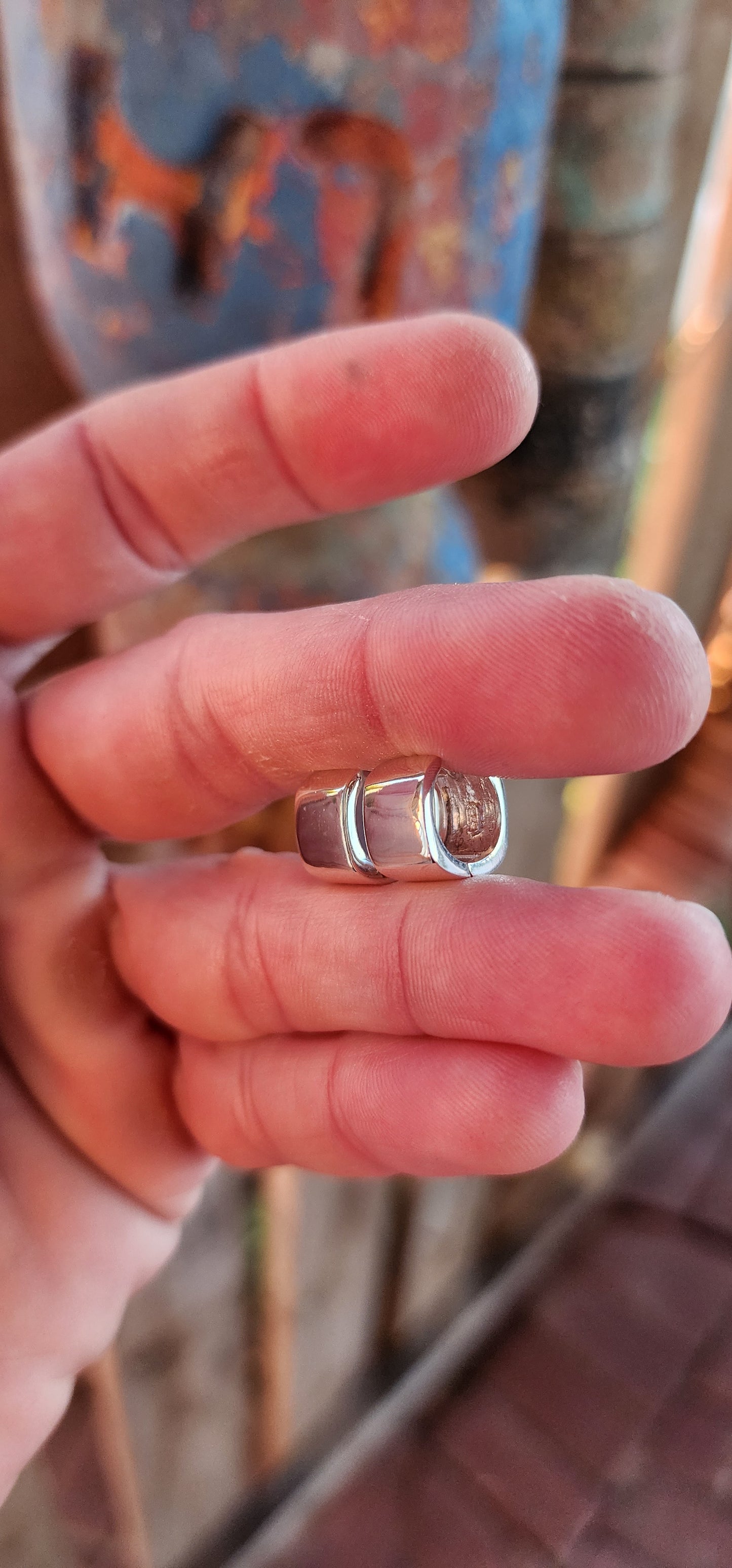 These sterling silver huggie earrings are a masterclass in modern minimalism, sculpted in a bold rounded-rectangular shape that hugs the ear with contemporary charm.