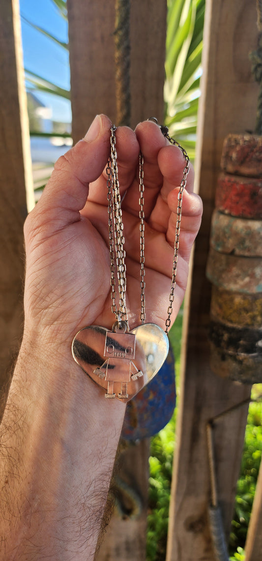 This necklace is pure quirky charm meets retro-futuristic flair!
Crafted in sterling silver, this artisan-made, extra-length necklace features a playful pendant duo that’s sure to spark conversation wherever you go.