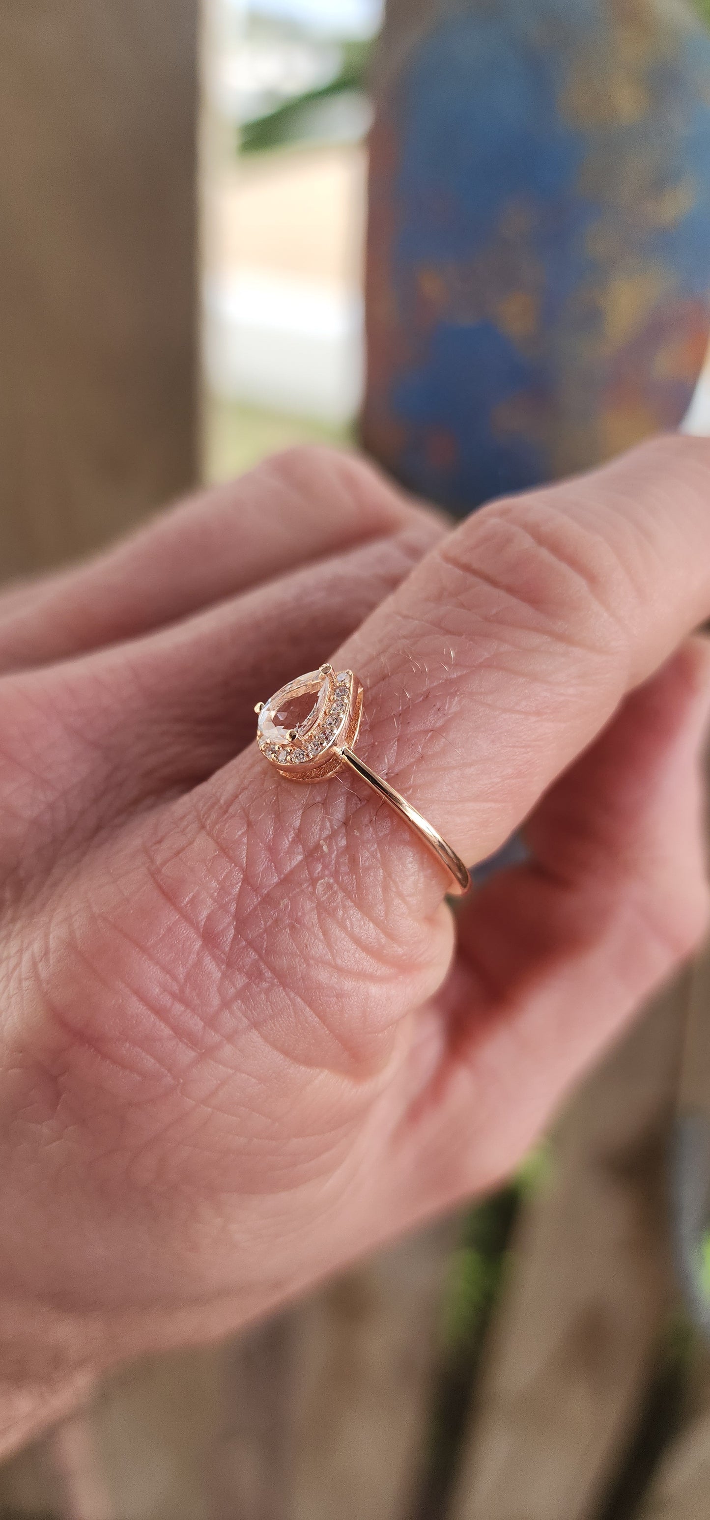 As delicate as the morning's first kiss of sunlight, this enchanting ring is a love letter in rose gold over sterling silver . Nestled at its heart is a pear-cut morganite gemstone, glowing softly like a drop of blushing dew caught at dawn.