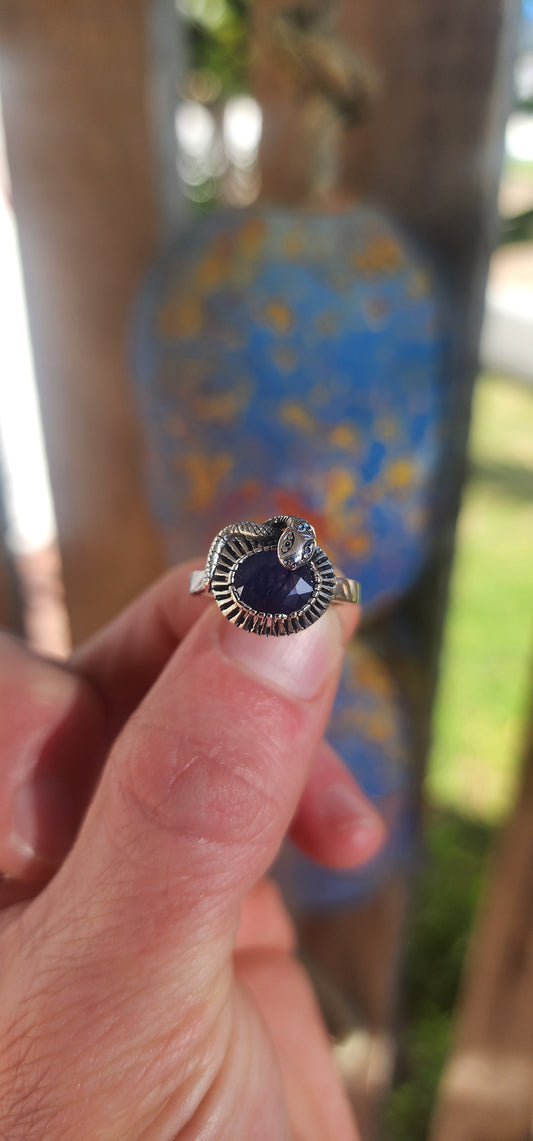 "Whispers of the Sapphire Serpent"
This sterling silver ring is like a mysterious legend coiled delicately around your finger! At its heart sits a deep blue oval-cut sapphire, faceted to perfection, glowing like a hidden midnight lake under a starlit sky.