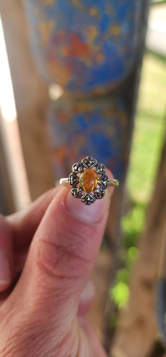This vintage-inspired beauty is like a whispered love letter from another era, where craftsmanship was poetry and gemstones carried stories. Cast in glowing sterling silver, the ring gently cradles an exquisite oval Ethiopian opal cabochon.