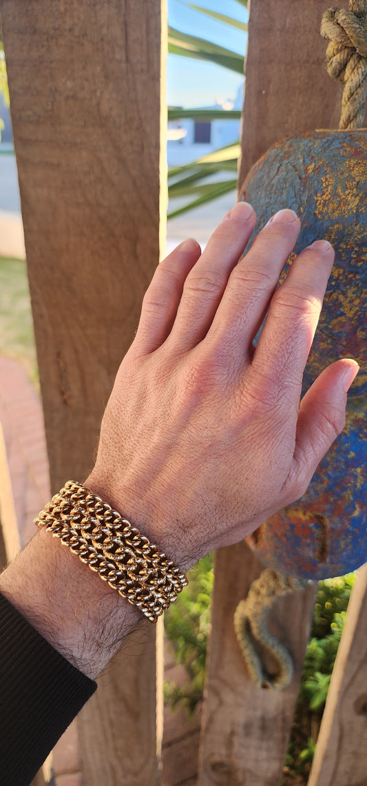 A rare survivor of mid-century mastery, this vintage rosy-yellow gold plated bracelet transforms simple curb links into a richly textured tapestry of bold elegance.