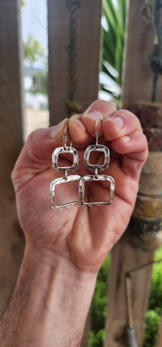 These artisan-made modernist drop earrings are crafted in sterling silver with a bold, sculptural flair.