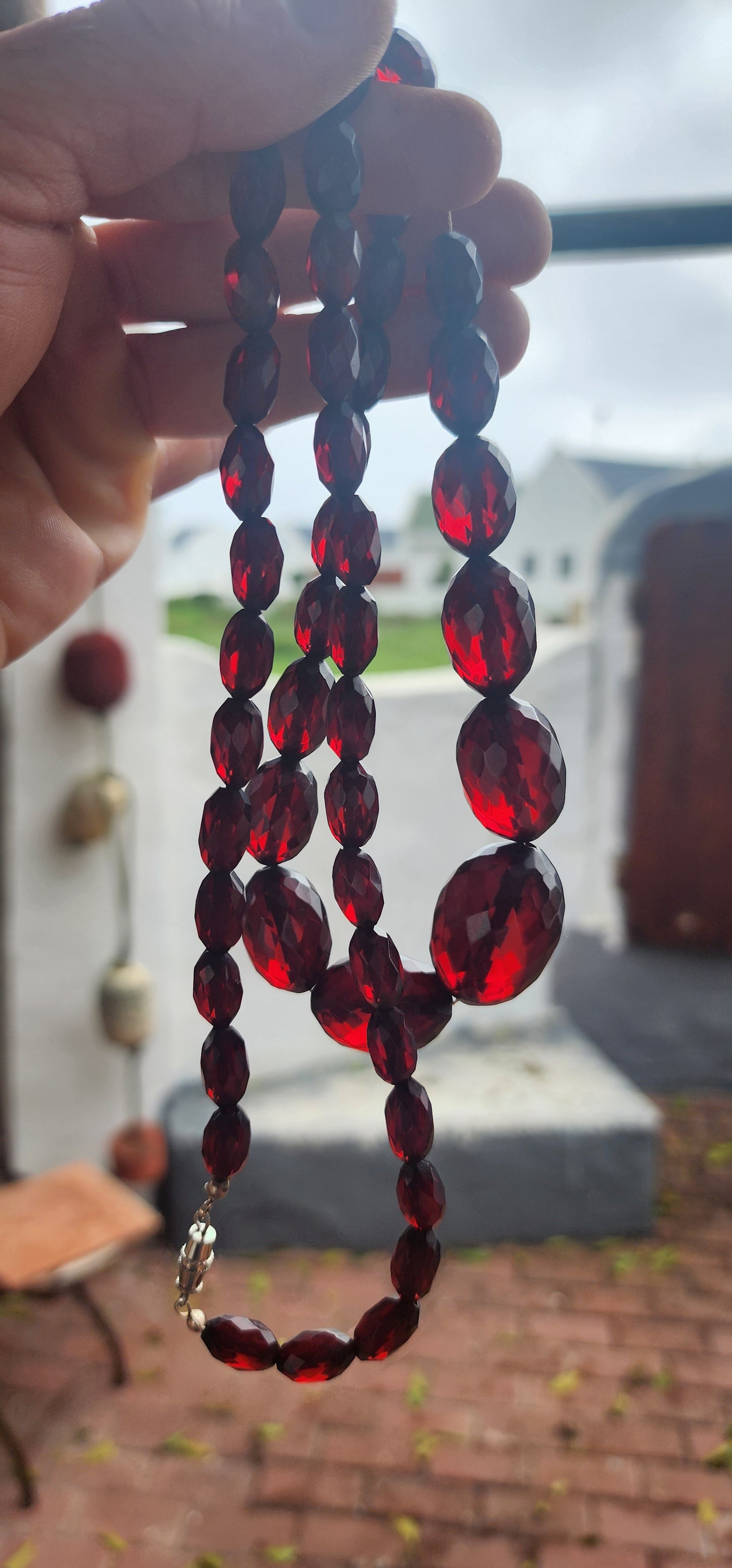 This exquisite vintage necklace is a radiant example of 1930s Art Deco glamour, showcasing hand-faceted cherry Bakelite beads in a beautifully graduated design.