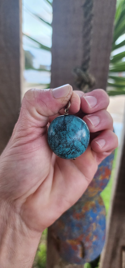 This striking pendant by Kirsten Goss features a generously sized turquoise gemstone, showcasing its signature black veining in vivid blue-green hues.