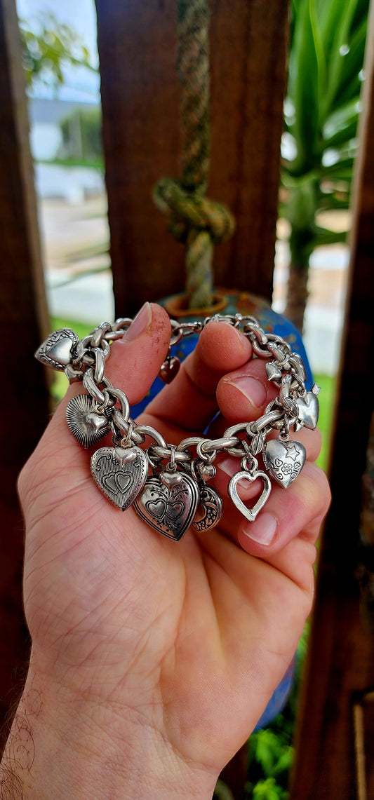 Exquisite designer costume charm bracelet by the celebrated French house Gas Bijoux. Crafted with a substantial silver-plated oval-link chain, this bracelet is a joyful celebration of love, nostalgia, and bohemian spirit.