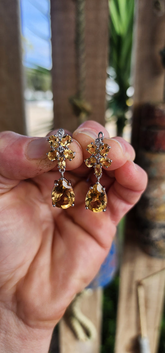 These elegant sterling silver drop earrings are a luminous tribute to nature’s golden glow, with a design inspired by delicate orchid blossoms.