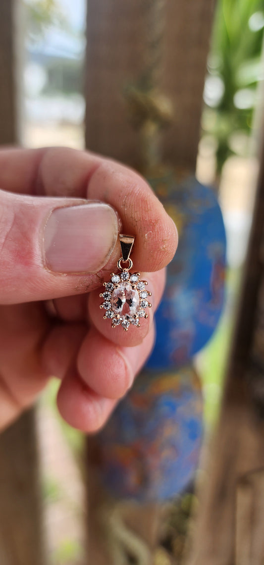 This enchanting pendant is crafted in warm rose gold-plated sterling silver, designed in a refined oval halo style. At its heart rests a soft blush-pink oval-cut morganite, glowing with gentle feminine radiance.
