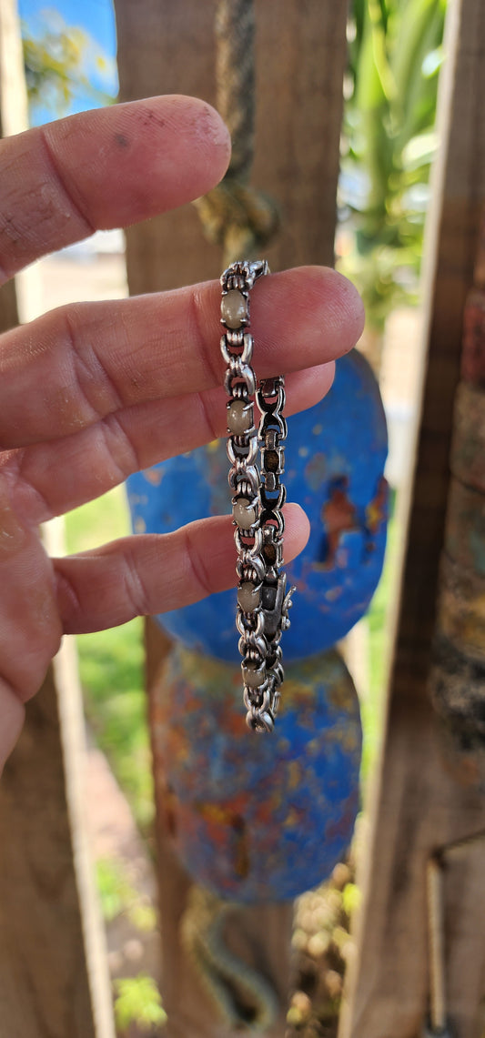 This unisex sterling silver tennis-style bracelet strikes a perfect balance between strength and subtle elegance. Set along its length are 11 oval cabochon quartz gemstones, their soft beige and off-white hues lending a natural, understated charm.