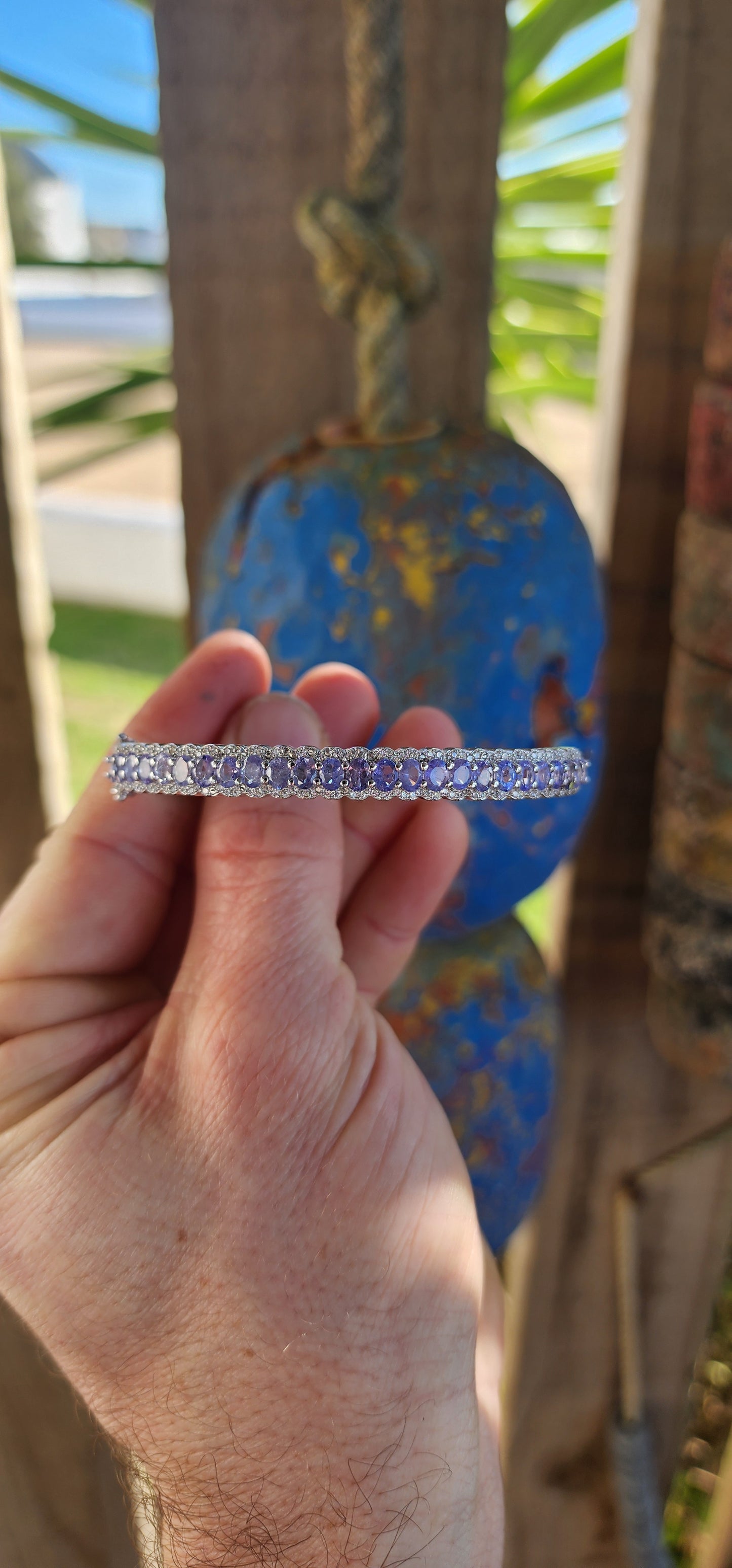 This classical sterling silver clip bangle dazzles with its timeless design and luxurious gemstone line-up. The front half of the bangle features a scalloped gallery adorned with 25 oval-cut Tanzanite gemstones.