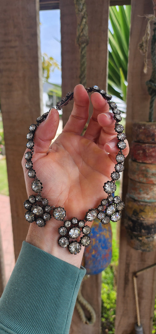 This spectacular and chunky 1960s French vintage costume choker necklace is a showstopper from every angle! Expertly crafted in silvertone metal, the entire necklace is encrusted with sparkly clear foiled-back paste glass rhinestones.