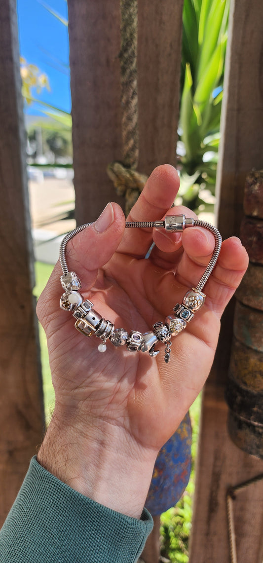 This delightful creation is a designer sterling silver snake chain charm bracelet by Donna Mia, brimming with character, sparkle, and storytelling.