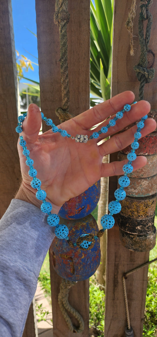 A marvelous survivor from the 1920s Art Deco era, this necklace is strung with a sequence of delicate hand-spun pierced lampwork beads in the most striking baby blue.