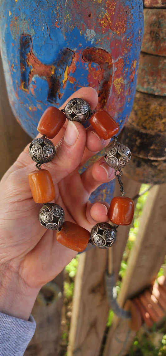 A striking and authentic example of North African Berber adornment, this bracelet is crafted with alternating chunky African amber beads and handmade sterling silver filigree spheres.