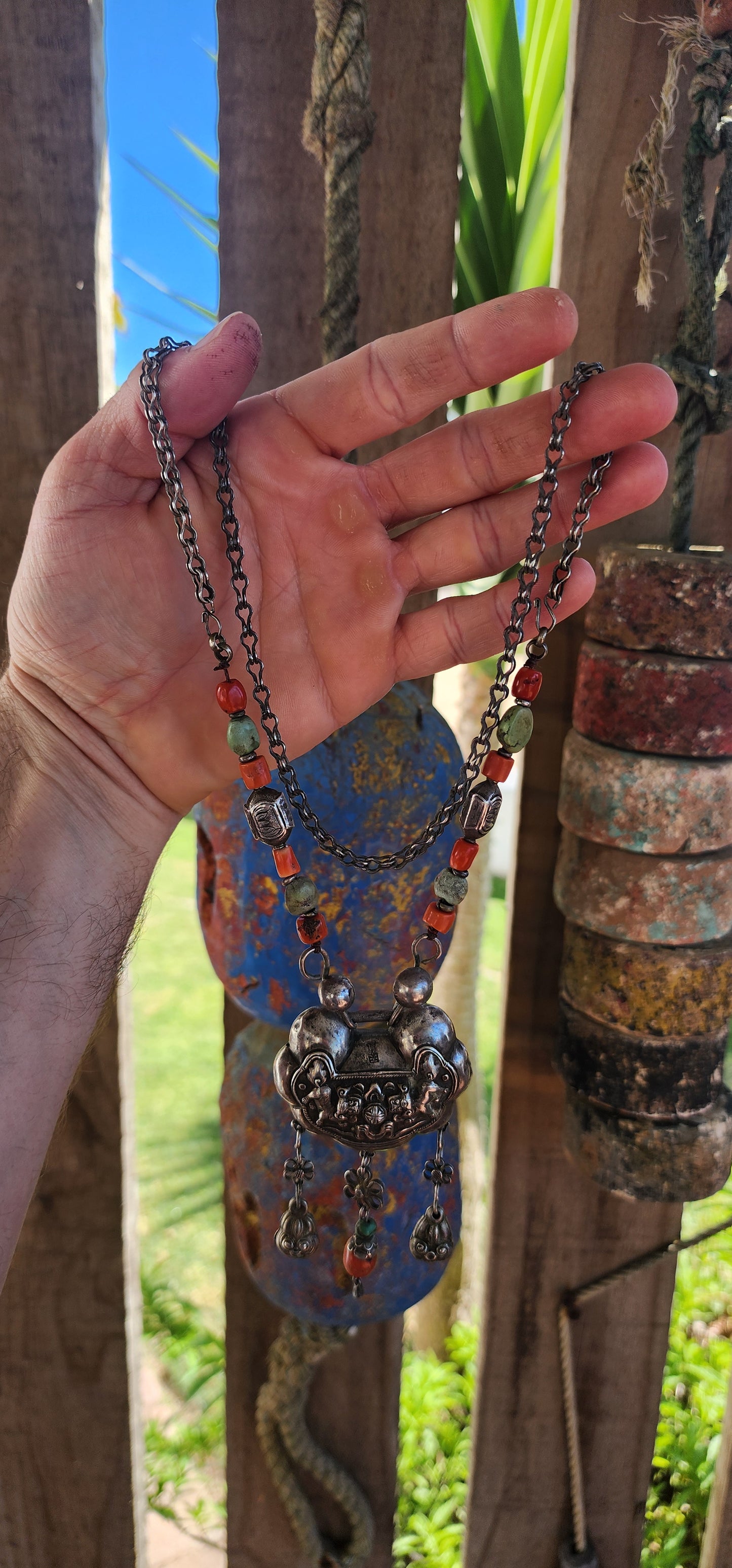 An extraordinary and highly collectible antique Chinese Qing Dynasty sterling silver “Longevity Lock” rattle pendant necklace, lavishly embellished with turquoise and coral bead accents and ornate dangle charms.